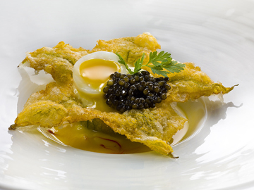 Deep-fried zucchini flower with caviar on shellfish and saffron consommé