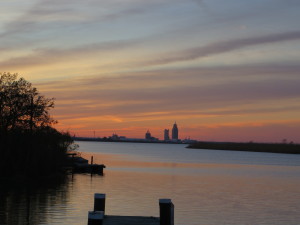 Sunset with the city of Mobile in the distance.